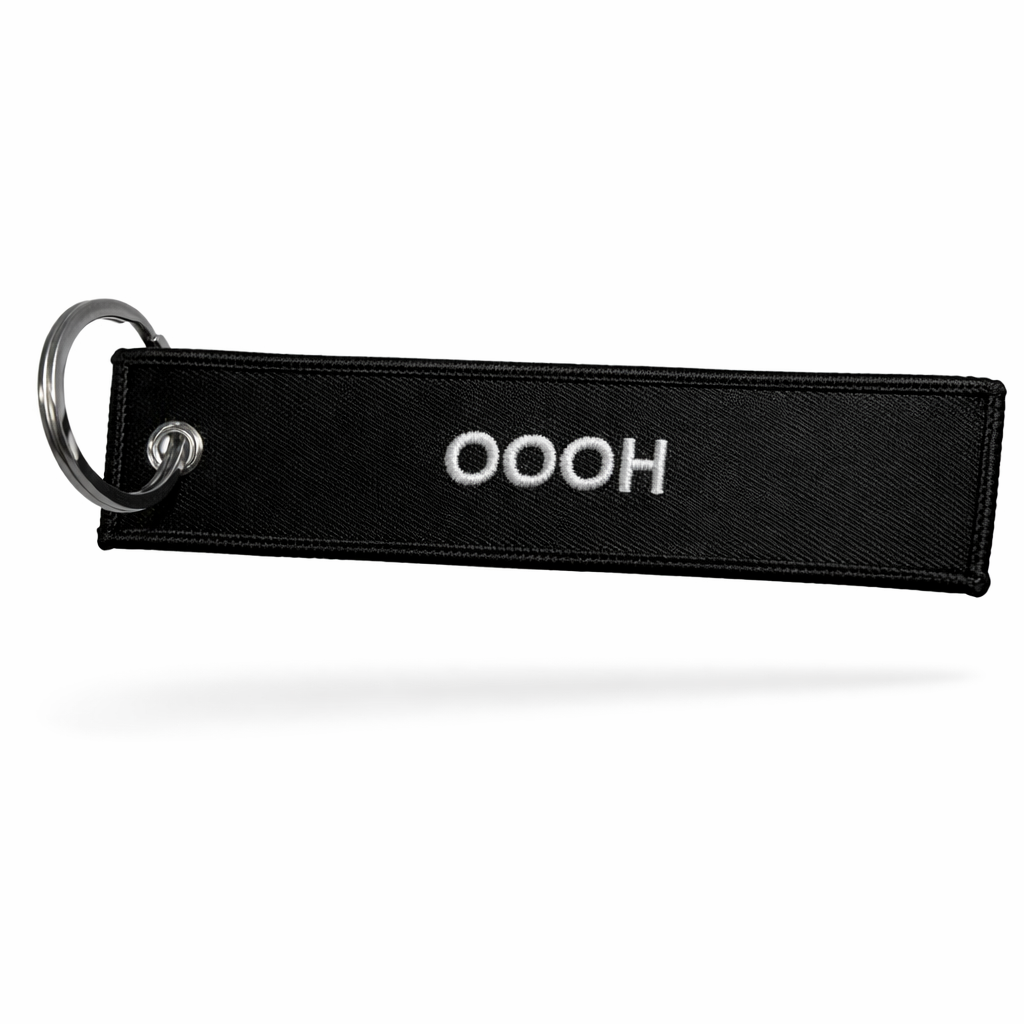 Reverse side of black Flight Tag with embroidered text by Sauce & Brown