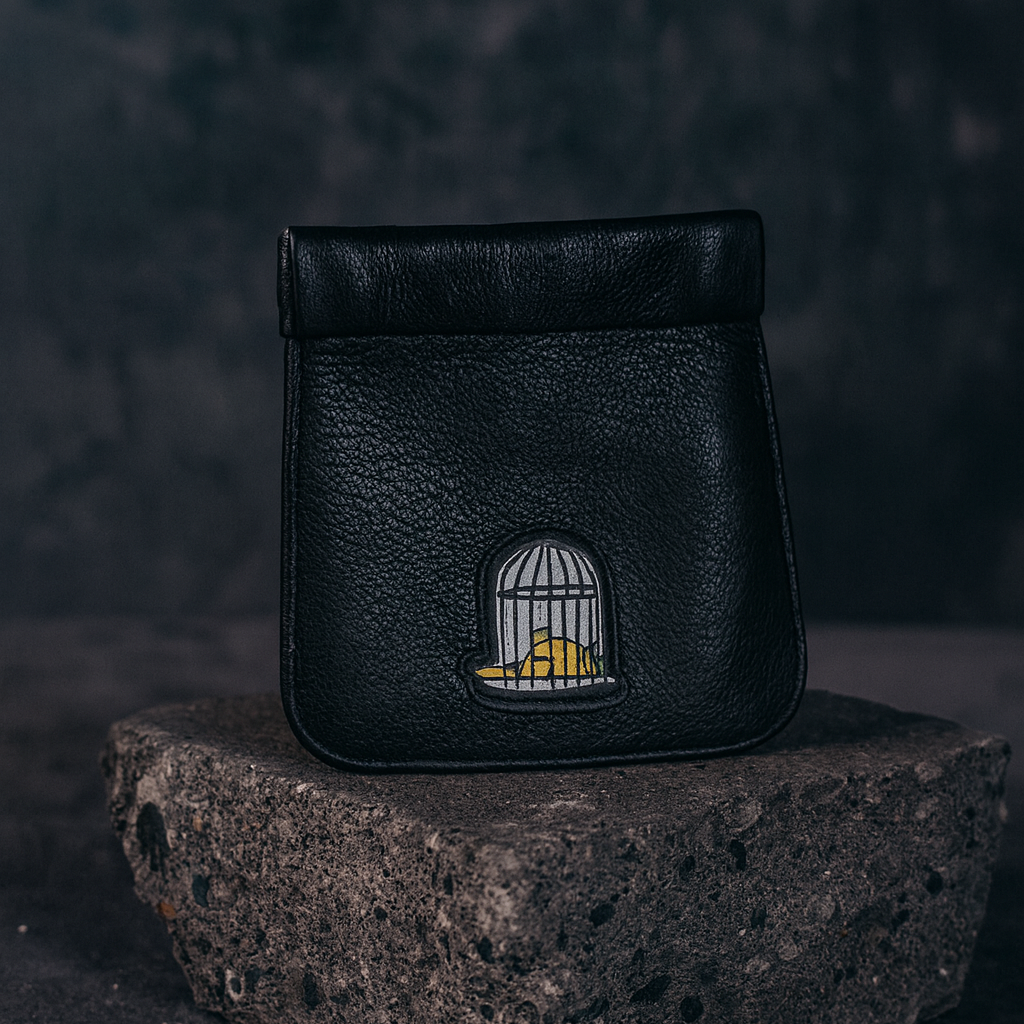 Leather snap top coin holder in black with embroidered logo on dark background by Sauce & Brown