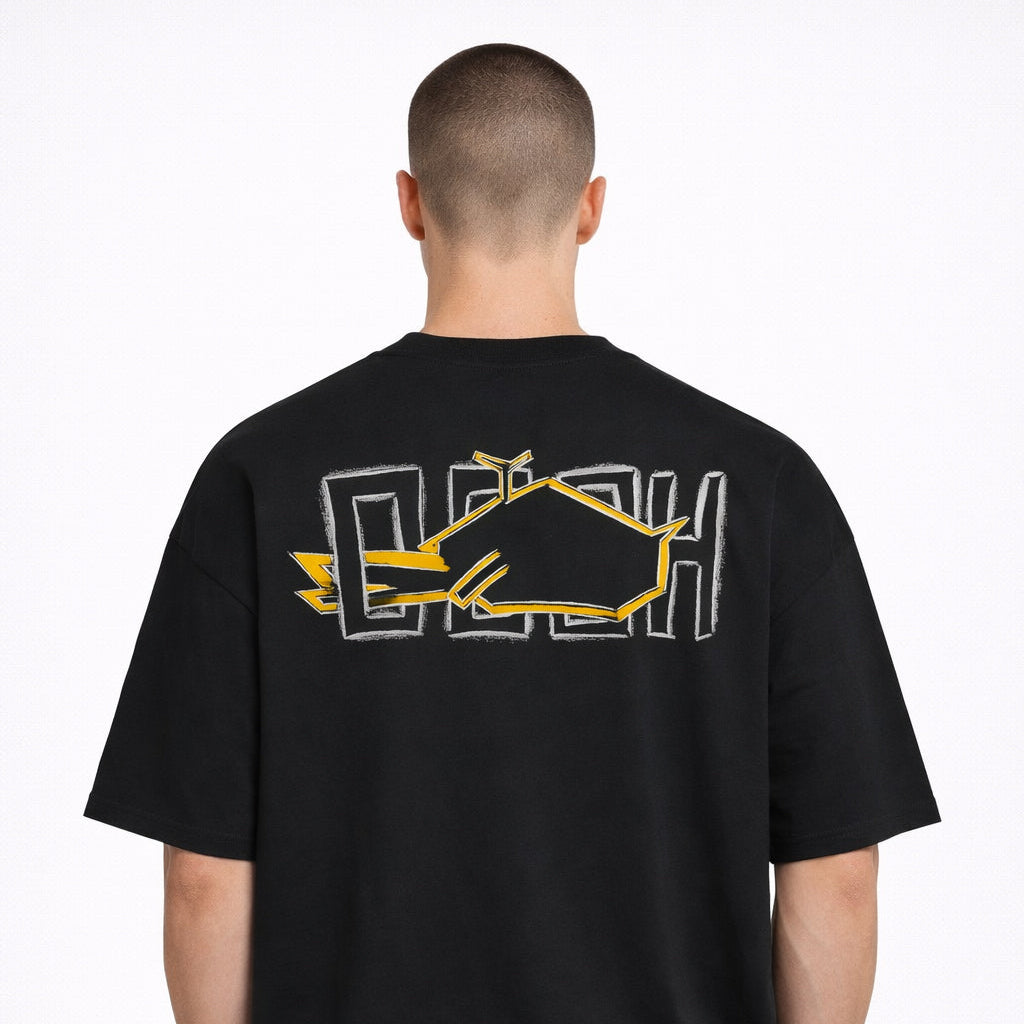 Rear view of Magnitude Box T-Shirt in black with large yellow back graphic worn by model by Sauce & Brown