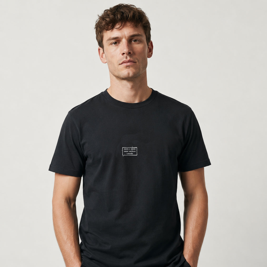 Front studio photograph of a male model wearing the Sauce & Brown Scratchback black T-Shirt.