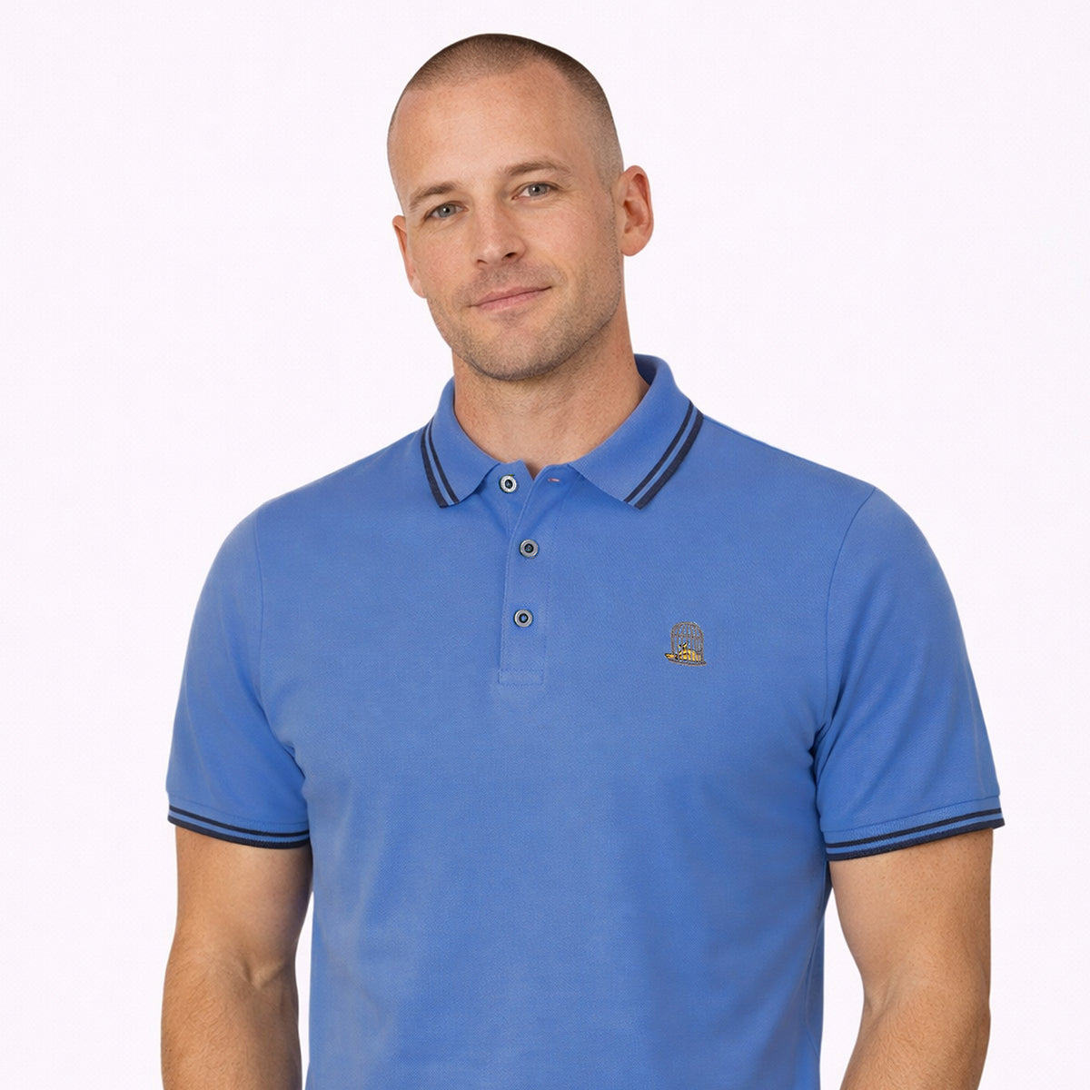 Male model wearing Mariner blue polo shirt with navy tipping and canary embroidery