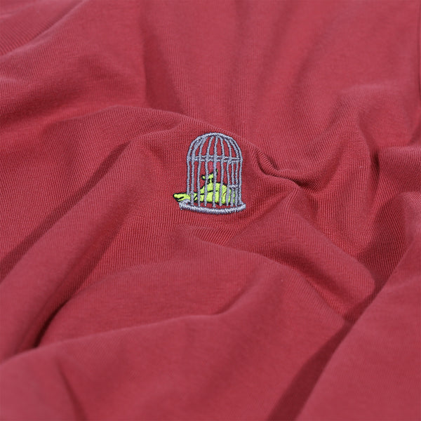 close up of the birdcage embroidery with a fluorescent canary