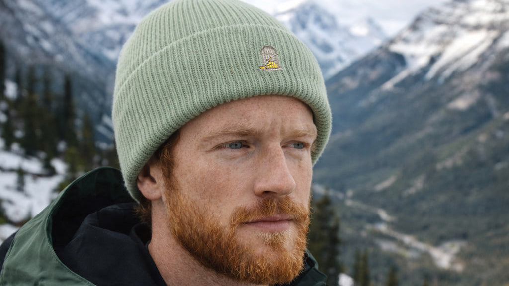Model wearing Alpine Beanie in Alpine Green outdoors in mountain setting by Sauce & Brown