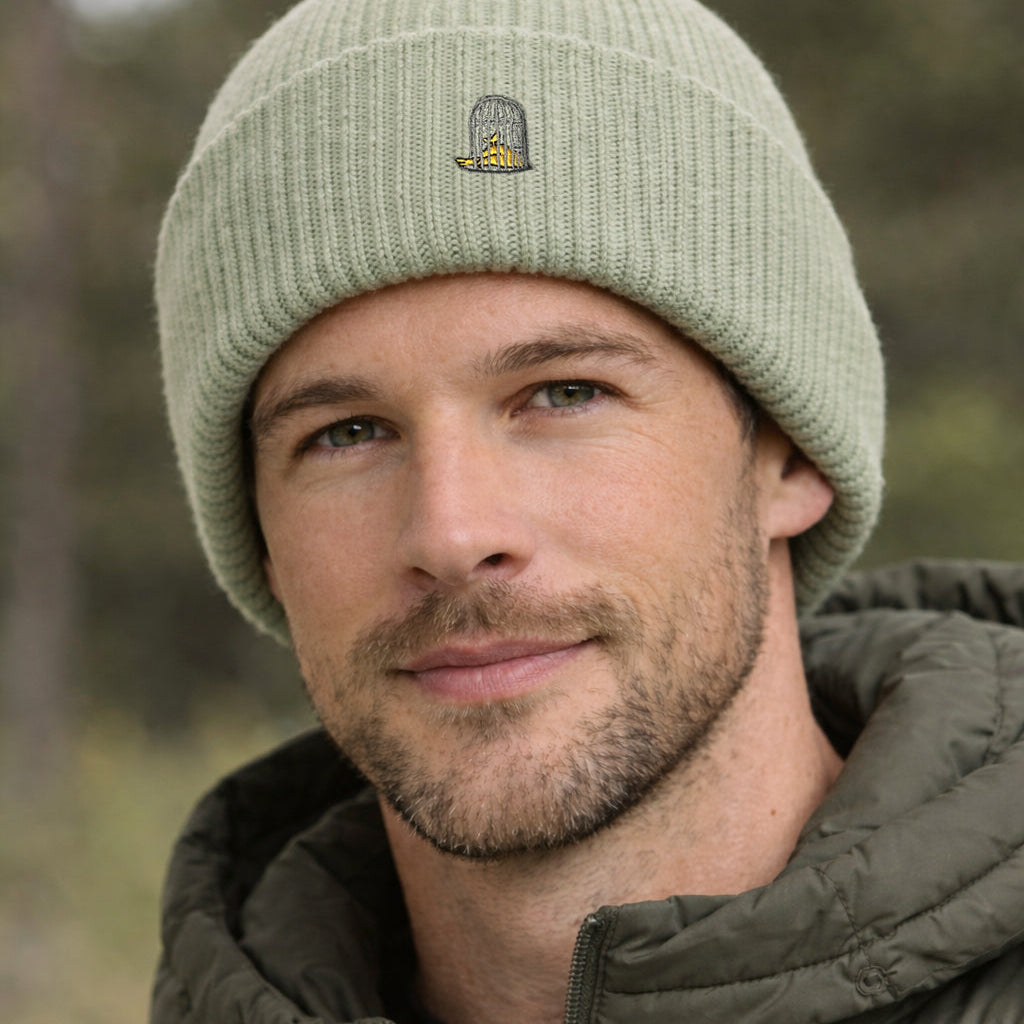 
Close-up of Alpine Beanie in Alpine Green worn by model showing embroidered logo by Sauce & Brown