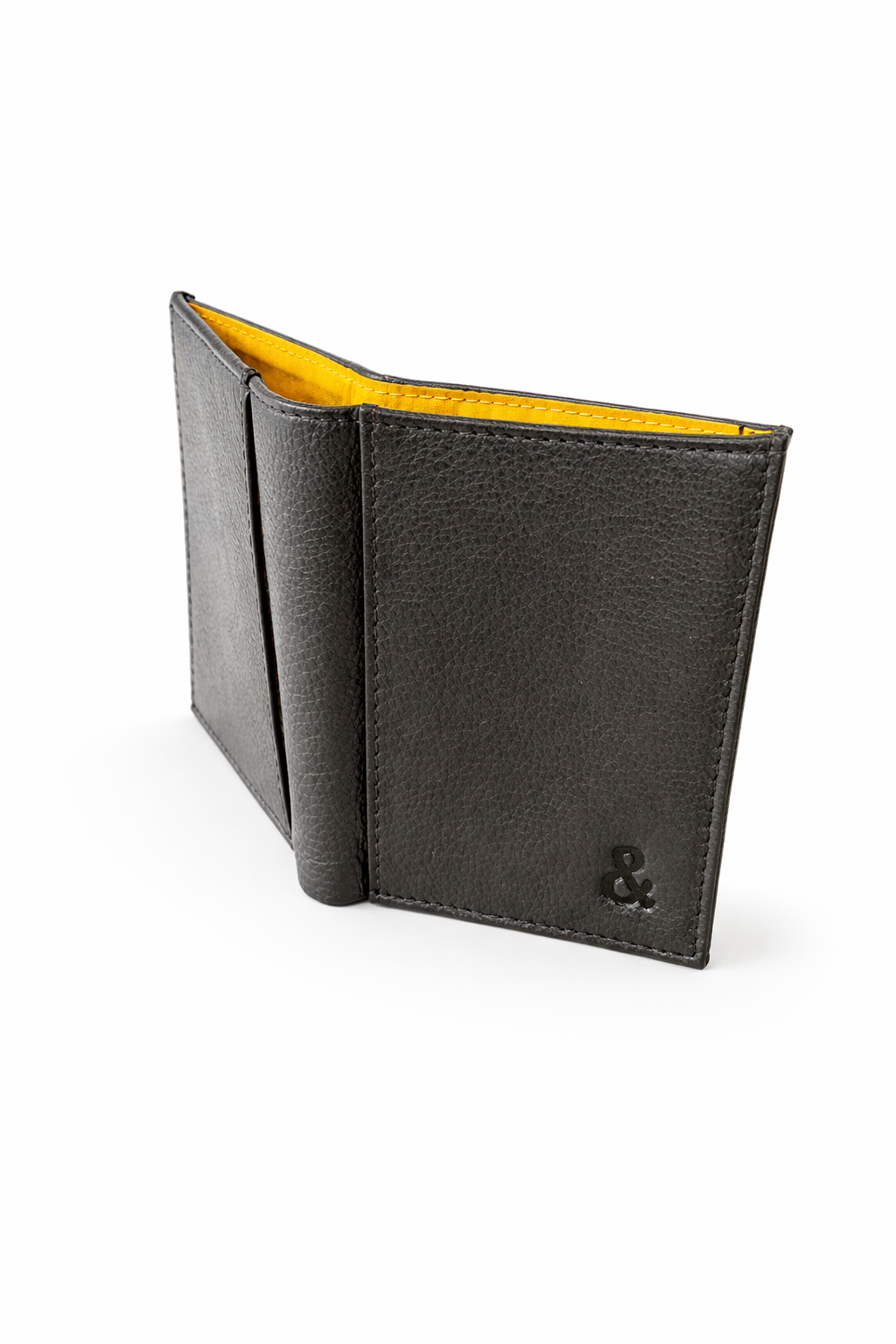 Angled view of black leather credit card holder showing yellow interior by Sauce & Brown