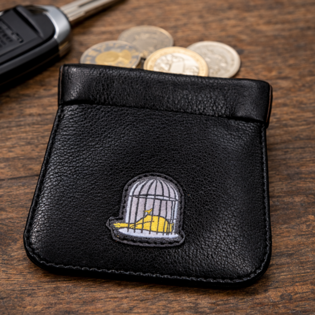 Black leather snap top coin holder with embroidered logo holding coins by Sauce & Brown