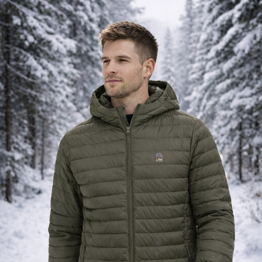 Model wearing Siege Jacket in olive green outdoors in snowy setting by Sauce & Brown