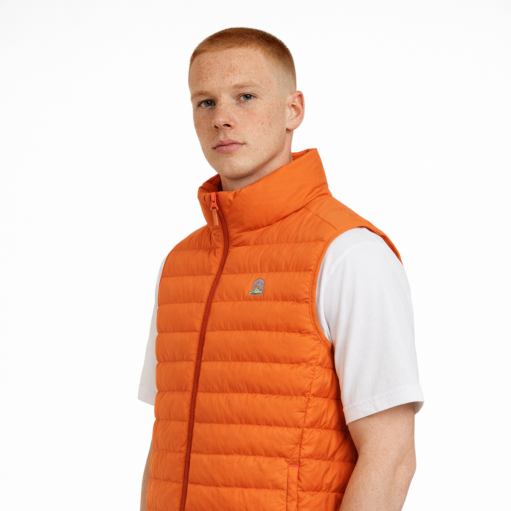Angled view of Sol Gilet in orange worn by model by Sauce & Brown