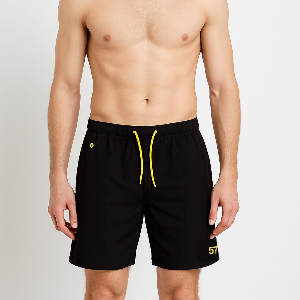 Swim Shorts in black with yellow drawcord worn by model by Sauce & Brown