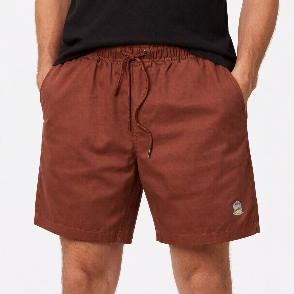Terra Shorts in earth red with embroidered logo worn by model by Sauce & Brown