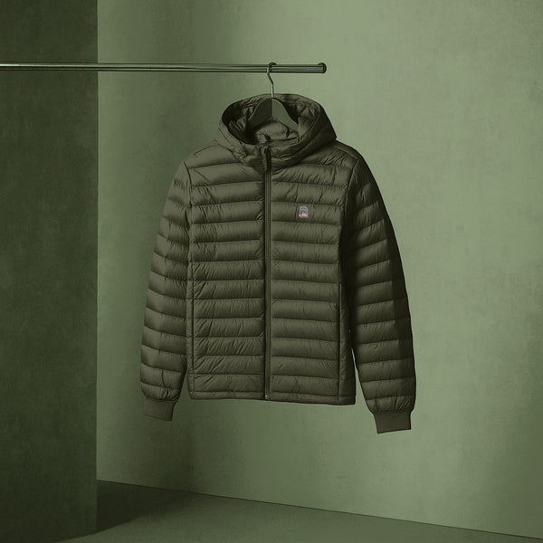 Sauce & Brown Green puffer jacket hanging on a rack against a green wall