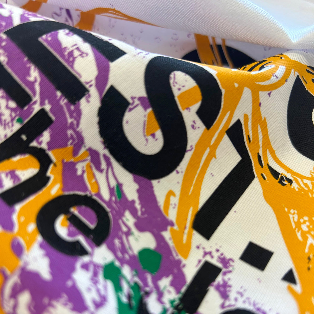 Close-up detail of white organic cotton T-shirt with S&B graphic print and textured fabric
