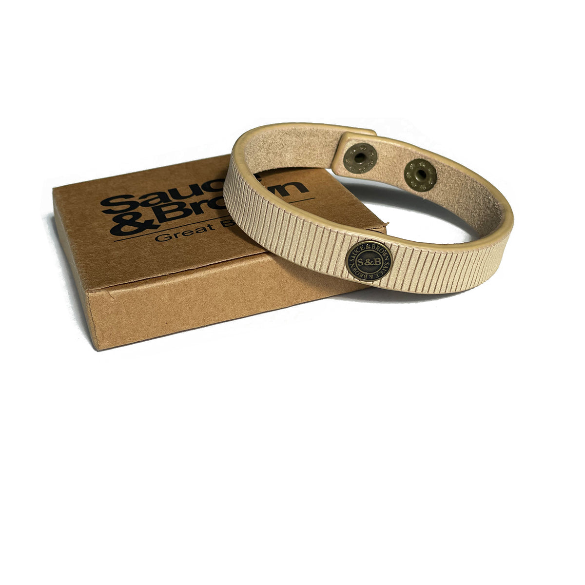 Beige leather band with Sauce & Brown branded packaging